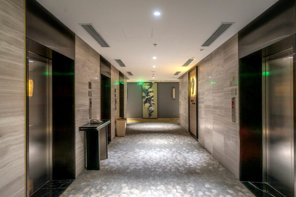 Spacious hotel hallway with elevators and contemporary decor.